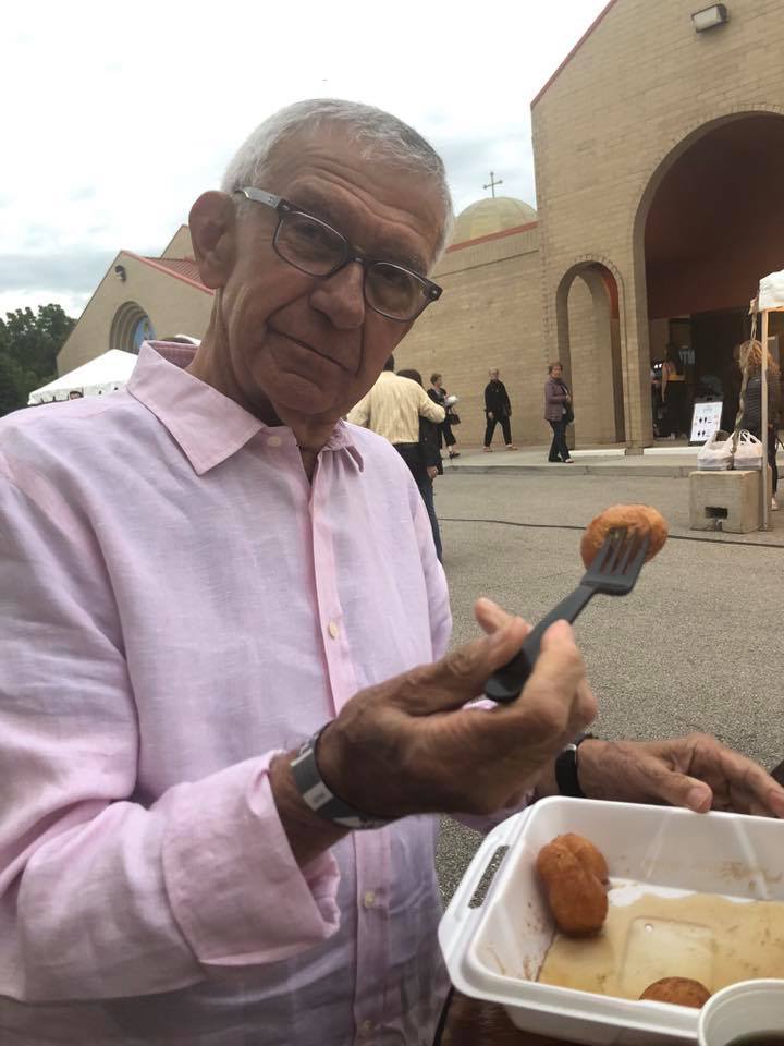 A man with a fork holding a container of food.