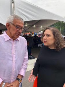 A man and woman talking in front of a tent.
