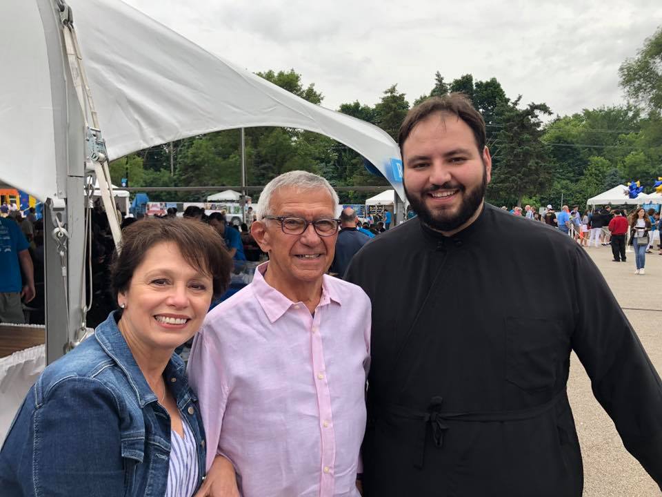 Three people posing for a photo in front of a tent.