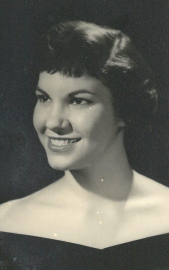 A black and white photo of a woman smiling.