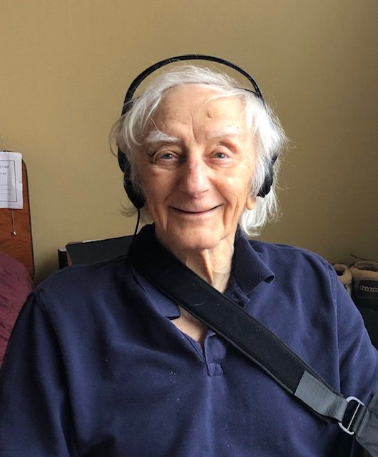 An older man wearing headphones in a room.