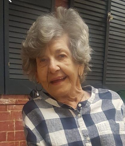 An older woman wearing a plaid shirt.