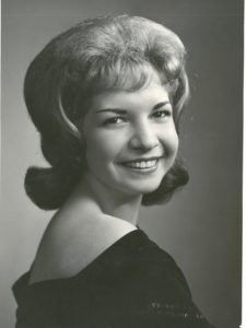 A black and white photo of a woman smiling.