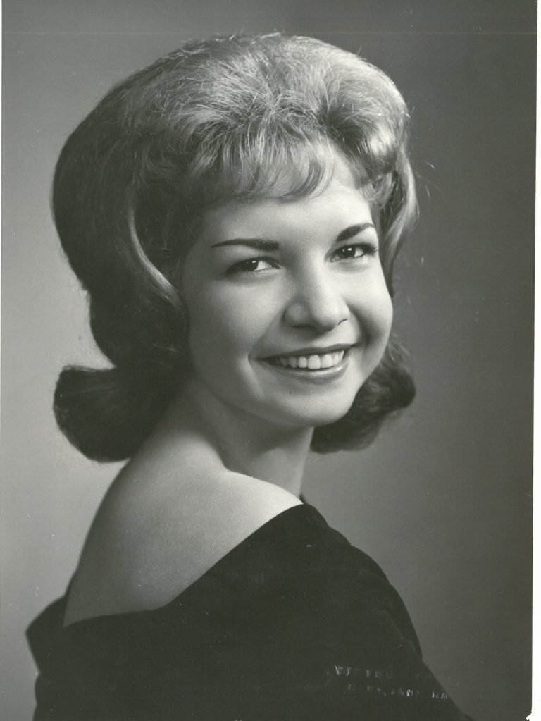A black and white photo of a woman smiling.
