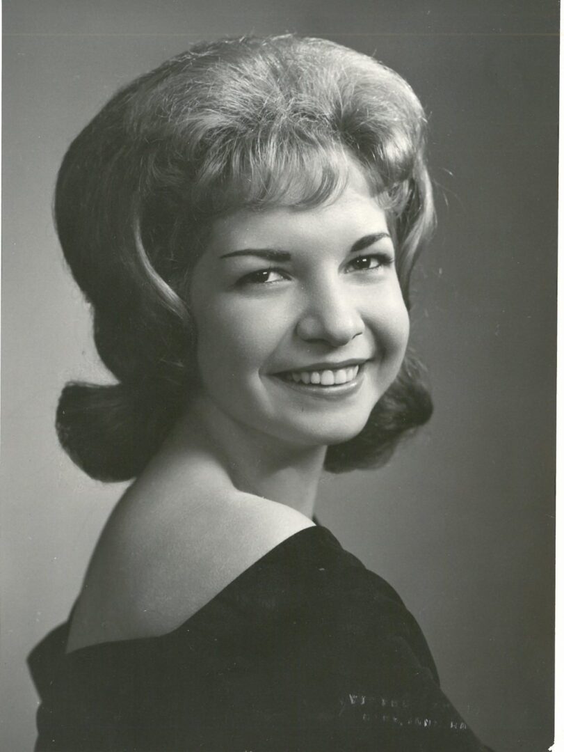A black and white photo of a woman smiling.