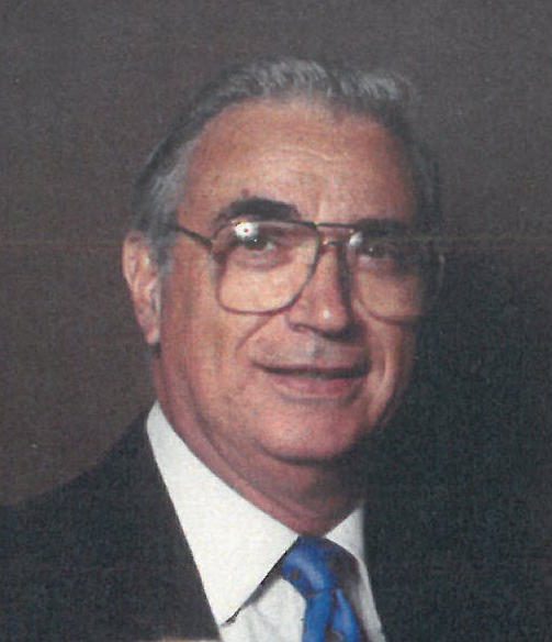 A man in a suit and tie is posing for a photo.