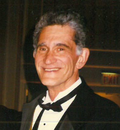 A man in a tuxedo smiling for the camera.