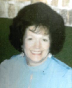 A woman in a blue shirt smiles for the camera.