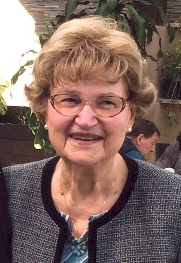 An older woman is smiling for the camera.