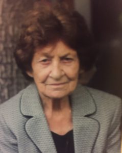 A photo of an older woman in a suit.