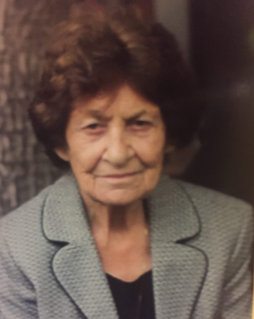 A photo of an older woman in a suit.