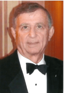 An older man in a tuxedo posing for a photo.