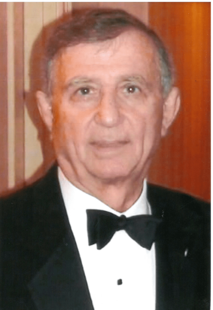 An older man in a tuxedo posing for a photo.