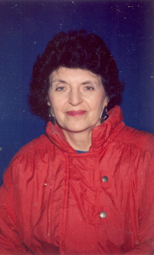 An older woman in a red jacket posing for a photo.