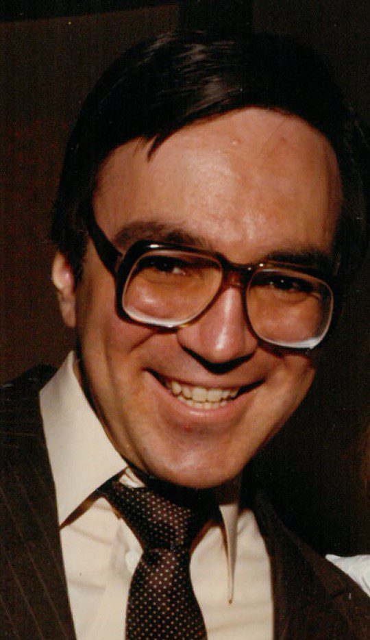 A man in glasses and a woman in a suit.