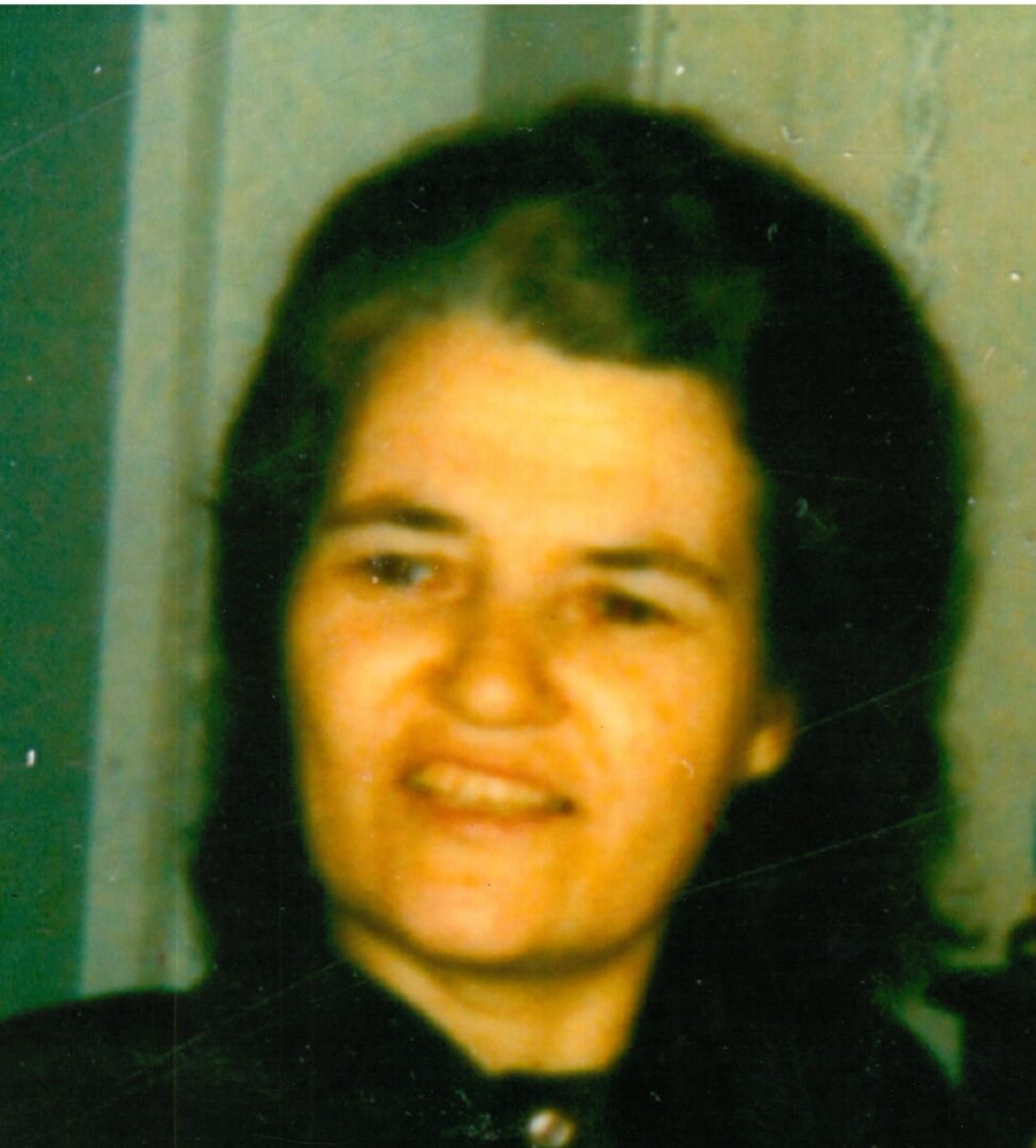 An old photo of a woman wearing a black shirt.