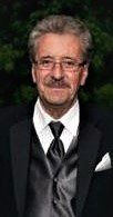 A man in a tuxedo posing for a picture.