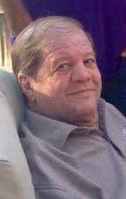 A man sitting in a chair with a smile on his face.
