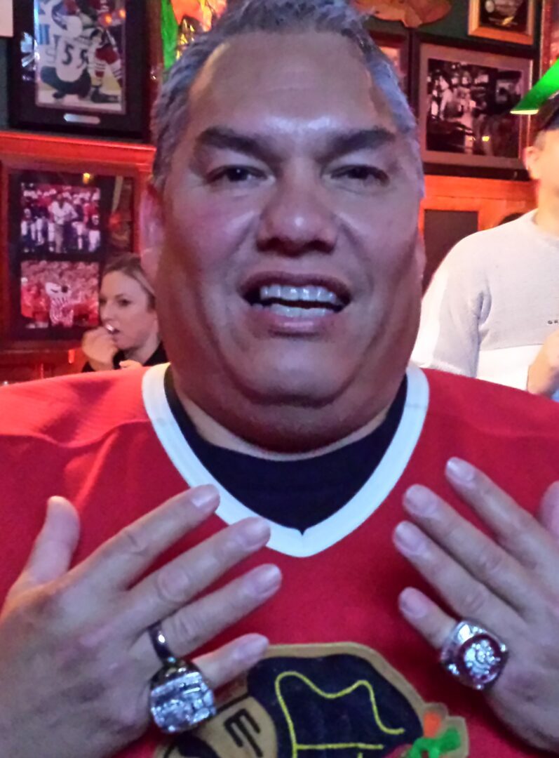 A man in a chicago blackhawks jersey is posing for a picture.