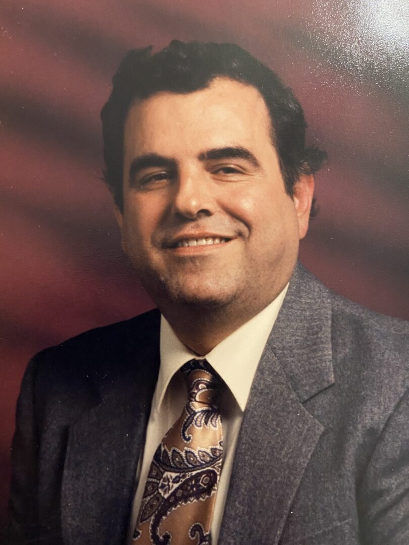 A photo of a man in a suit and tie.