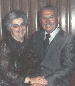 An older man and woman posing for a photo.