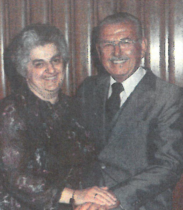 An older man and woman posing for a photo.