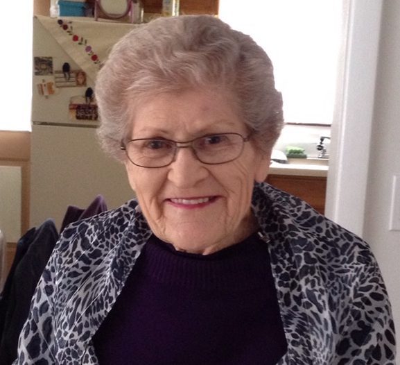 An older woman wearing glasses and a leopard print sweater.