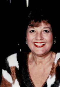 A woman in a striped sweater smiles for the camera.