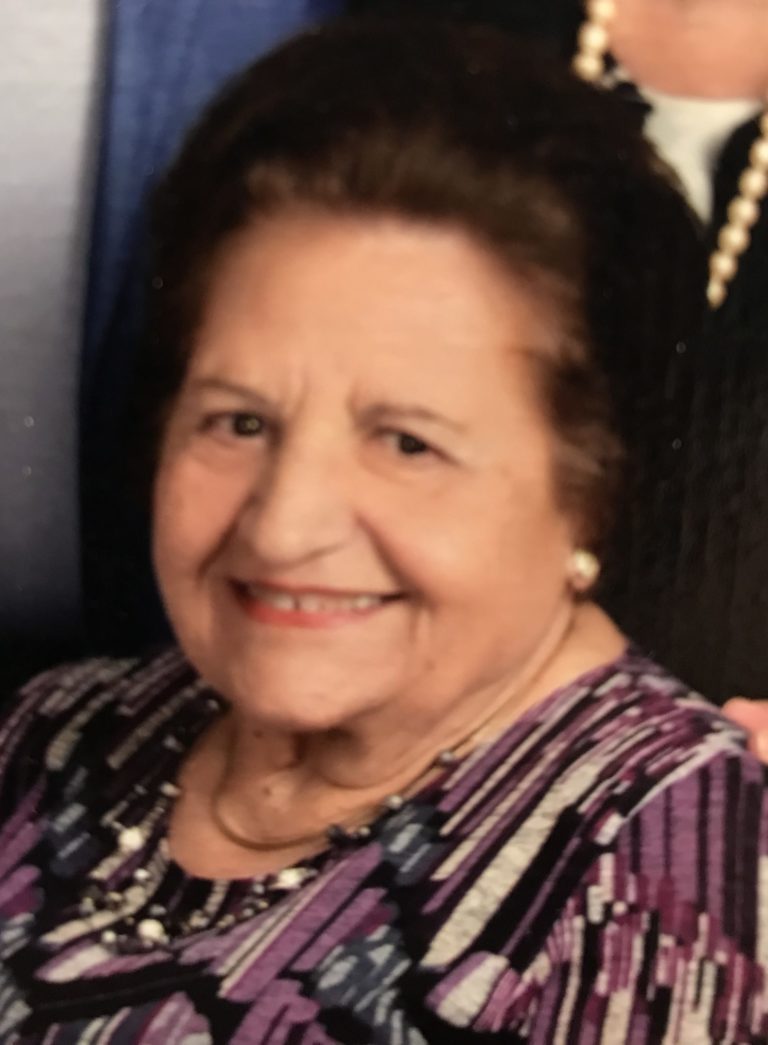 An older woman is smiling for the camera.