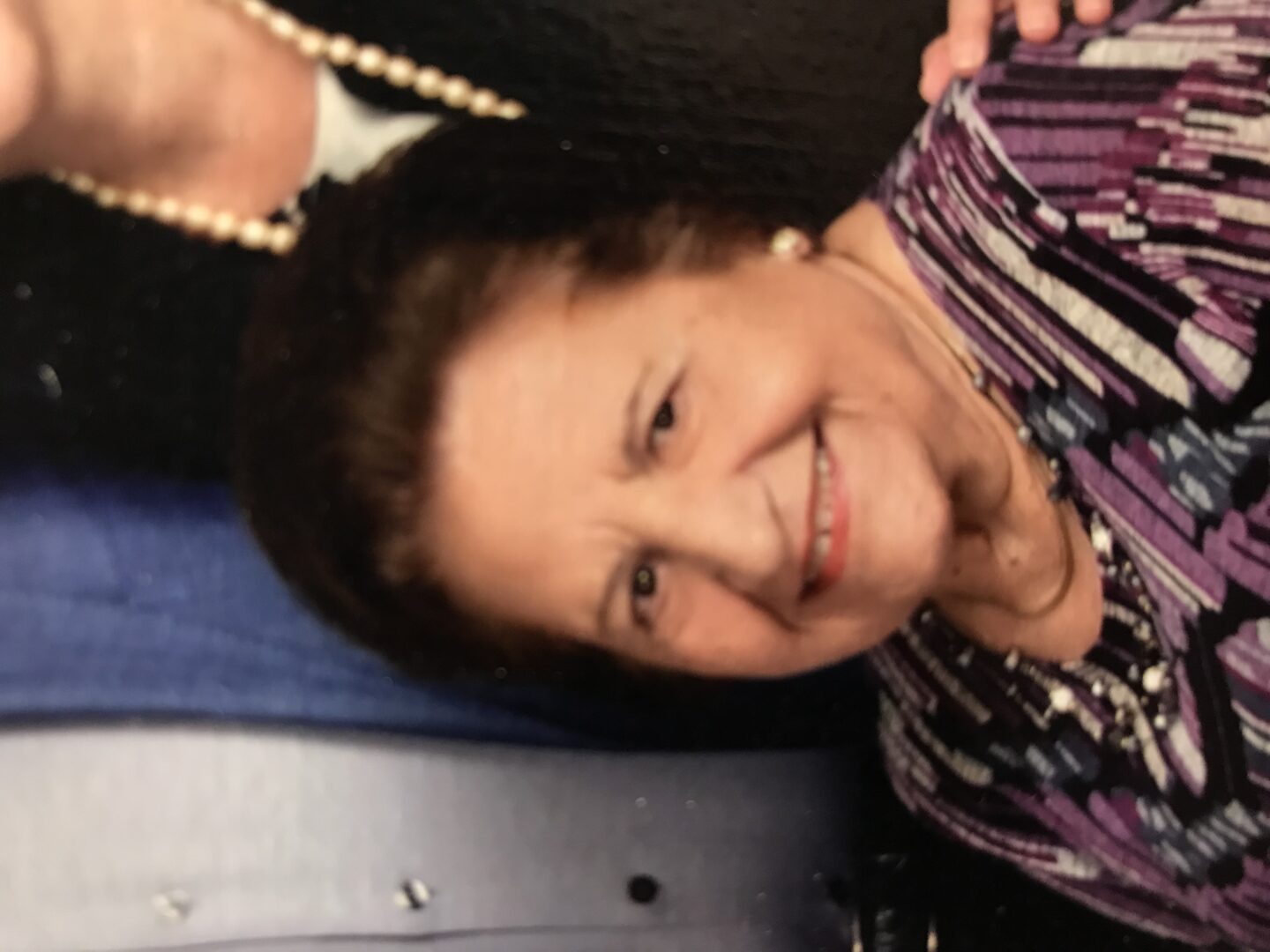 An older woman is smiling for the camera.
