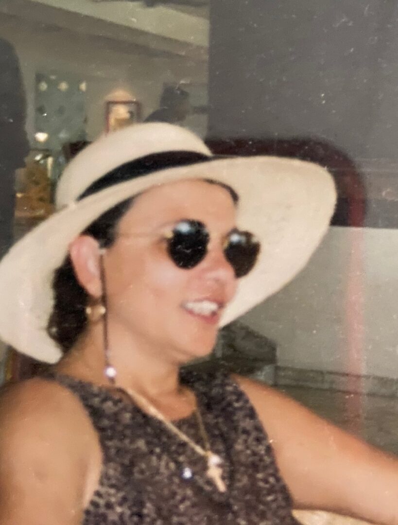 A woman wearing sunglasses and a hat.
