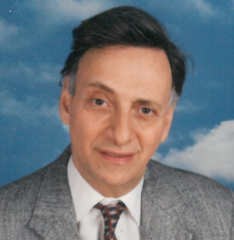 A man in a suit and tie is posing for a photo.
