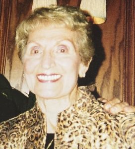 A woman in a leopard print jacket is smiling for the camera.