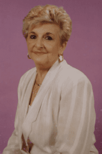 A woman in a white jacket is posing for a photo.