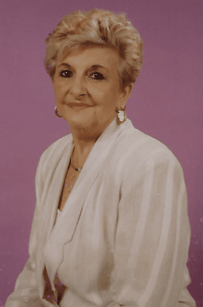 A woman in a white jacket is posing for a photo.