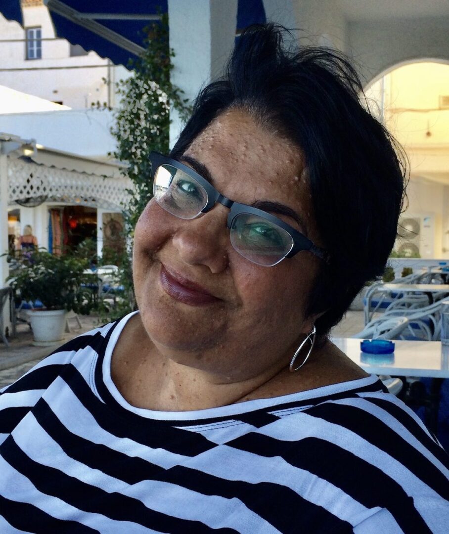 A woman wearing glasses and a striped shirt.