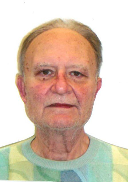 An older man is posing for a photo.