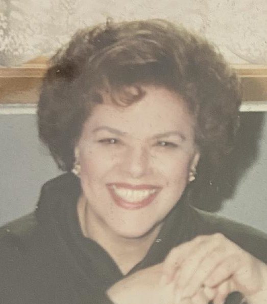 An old photo of a woman smiling.