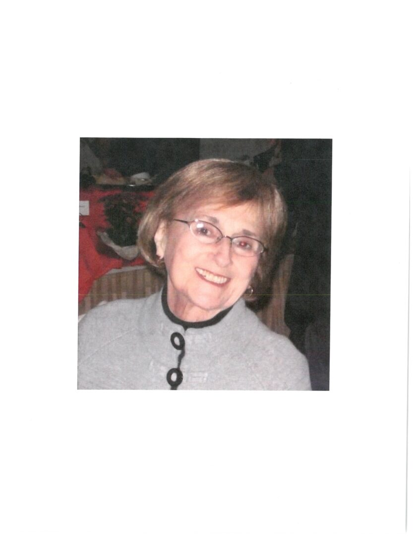 An older woman wearing glasses and a sweater.