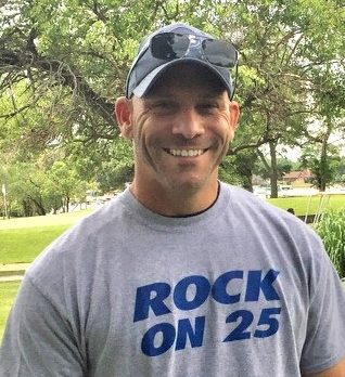 A man wearing a t - shirt that says rock on 25.