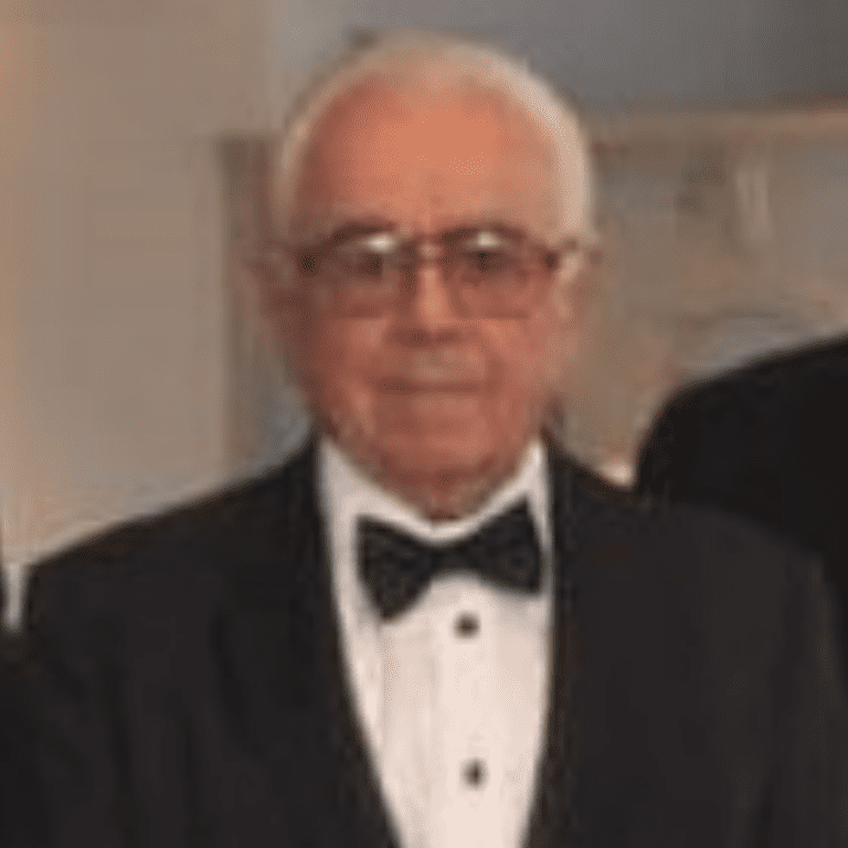 Three older men in tuxedos standing next to each other.