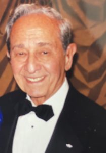 A man in a tuxedo and a woman in a blue dress.