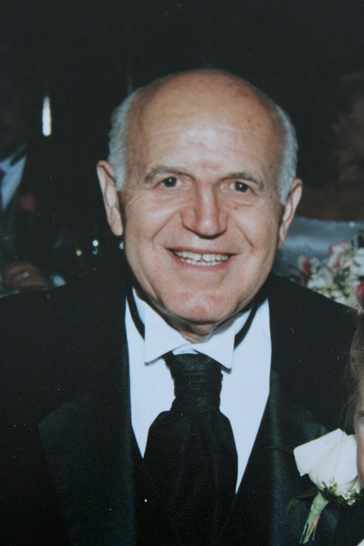 An older man in a tuxedo with a little girl.