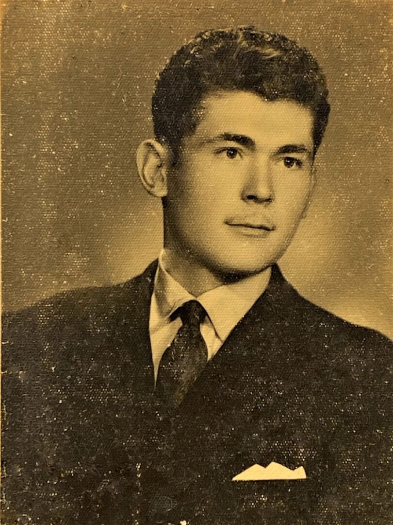 A photo of a young man in a suit and tie.