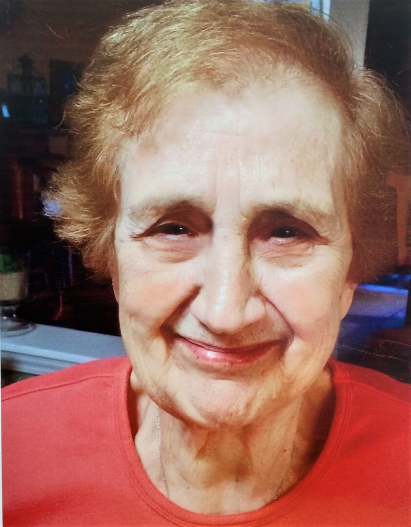 An older woman is smiling for the camera.