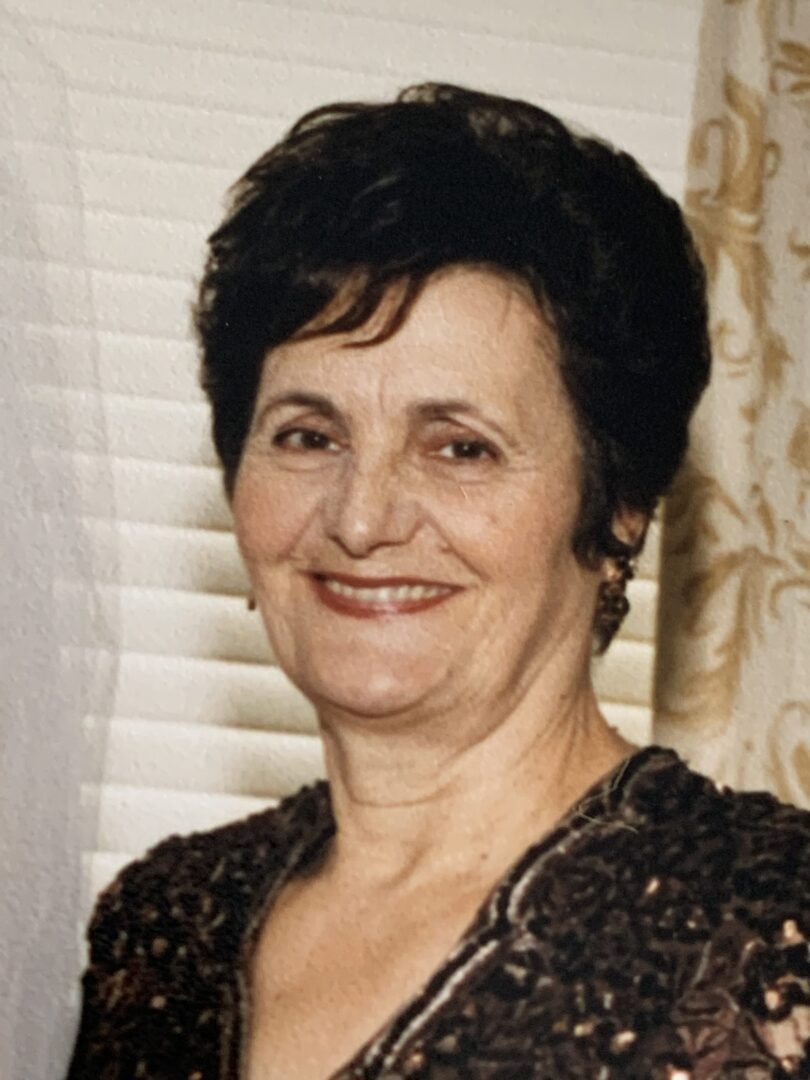 A woman in a wedding dress smiling for the camera.
