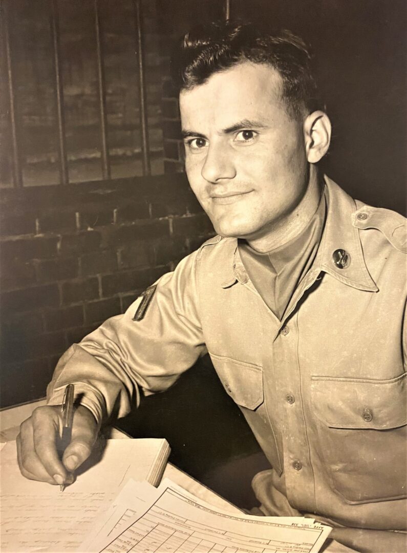 A man in uniform sitting at a desk.