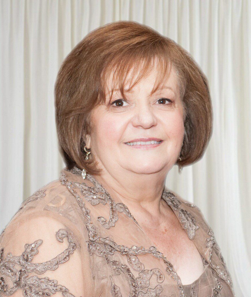 A woman in a brown dress posing for a photo.