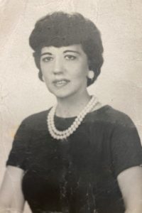 A black and white photo of a woman with pearls.