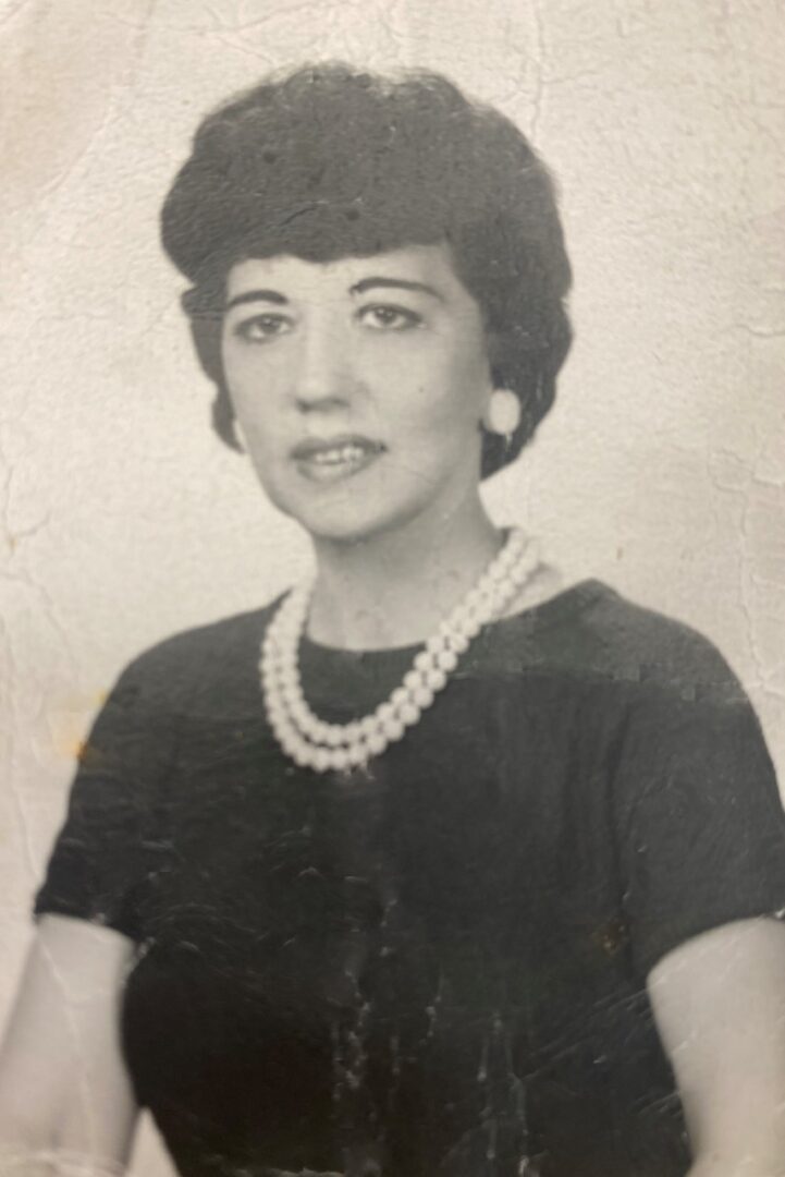 A black and white photo of a woman with pearls.